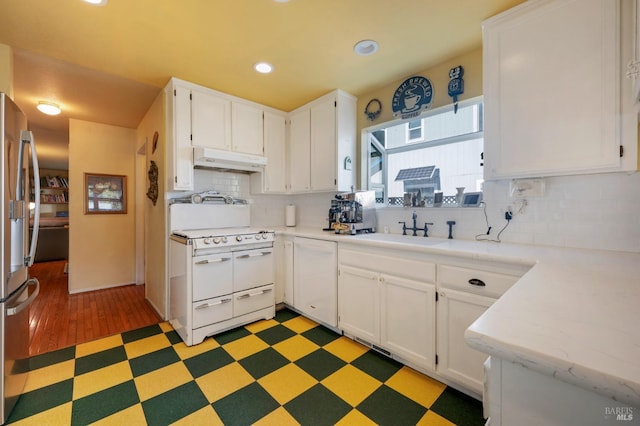 kitchen with white appliances, white cabinets, light floors, light countertops, and under cabinet range hood