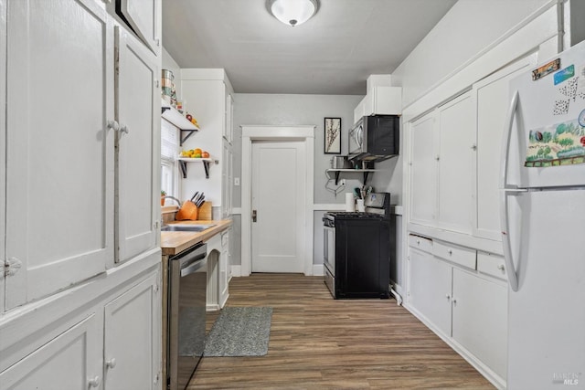 kitchen with hardwood / wood-style flooring, appliances with stainless steel finishes, sink, and white cabinets