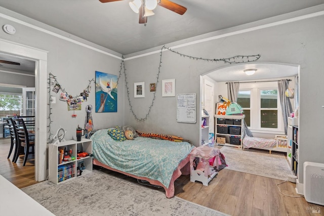 bedroom featuring ceiling fan, wood-type flooring, and multiple windows