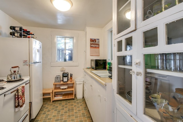 kitchen with white cabinets and white range with electric cooktop