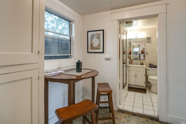 bathroom featuring toilet, tile patterned flooring, and sink