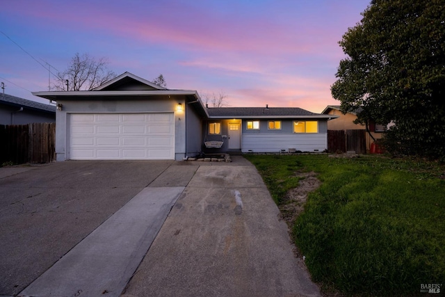 ranch-style home featuring a garage and a yard