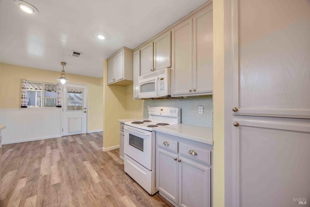 kitchen featuring white appliances, light hardwood / wood-style flooring, decorative light fixtures, and decorative backsplash