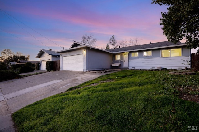 single story home featuring a garage and a yard