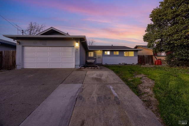 single story home featuring a garage and a lawn