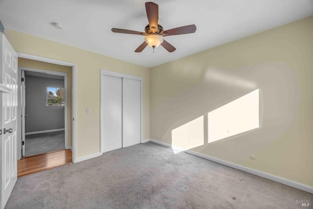 unfurnished bedroom featuring light colored carpet, a closet, and ceiling fan