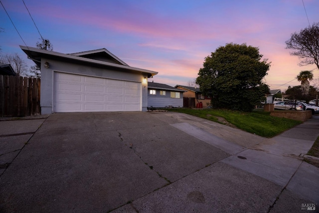 view of front of home featuring a garage and a yard