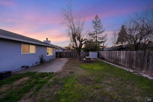 yard at dusk featuring a patio area