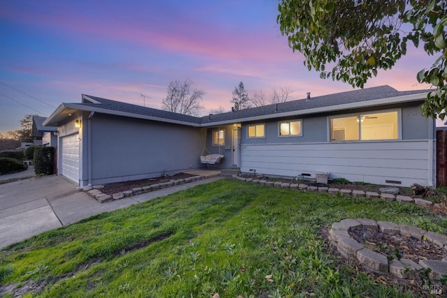 ranch-style house with a garage and a lawn