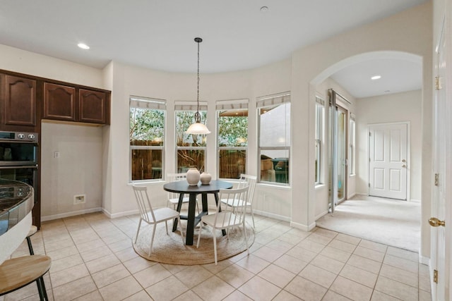 dining space featuring arched walkways, recessed lighting, baseboards, and light tile patterned floors