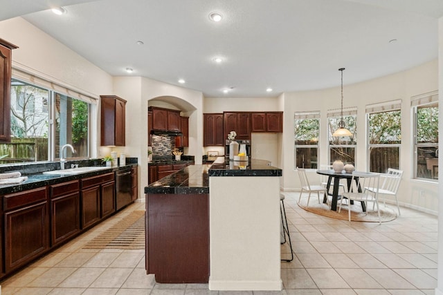 kitchen featuring light tile patterned floors, tile countertops, dishwashing machine, a sink, and recessed lighting