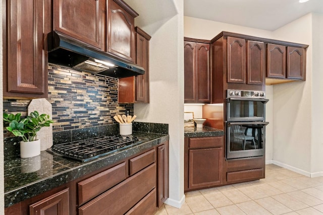 kitchen with black gas cooktop, decorative backsplash, stainless steel double oven, under cabinet range hood, and baseboards