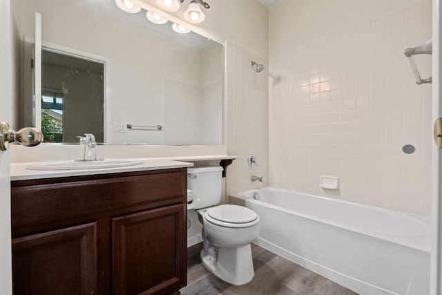 bathroom with toilet, tub / shower combination, wood finished floors, and vanity