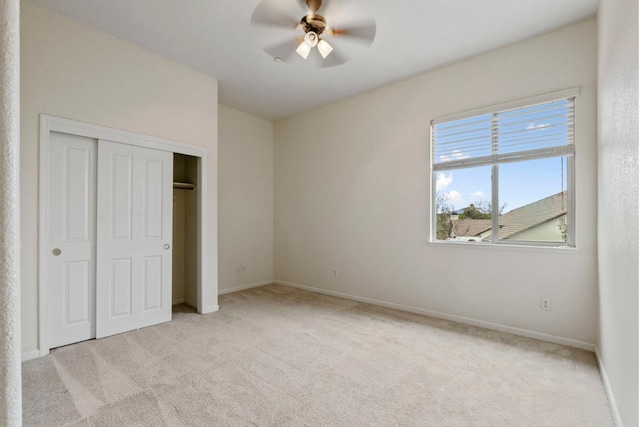 unfurnished bedroom with a closet, carpet flooring, a ceiling fan, and baseboards