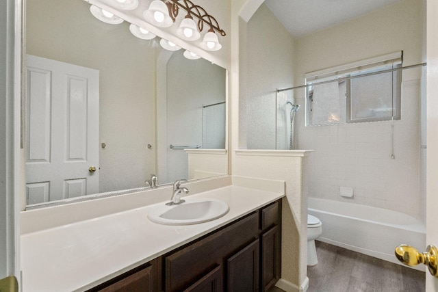 bathroom with toilet, bathtub / shower combination, wood finished floors, and vanity