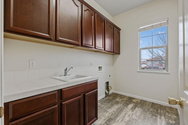 washroom featuring washer hookup, cabinet space, light wood-style flooring, hookup for an electric dryer, and a sink