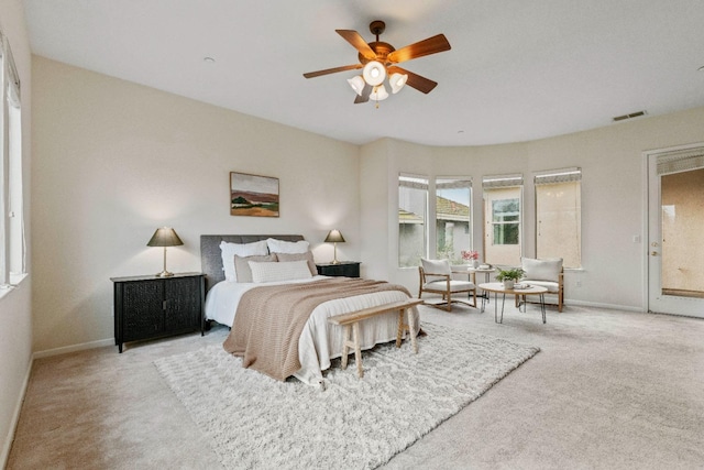 carpeted bedroom with visible vents, baseboards, and a ceiling fan