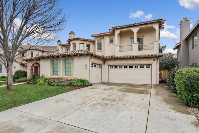 mediterranean / spanish-style house with an attached garage, a balcony, concrete driveway, stucco siding, and a front lawn