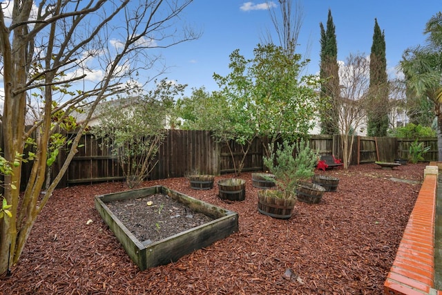 view of yard with a fenced backyard and a garden