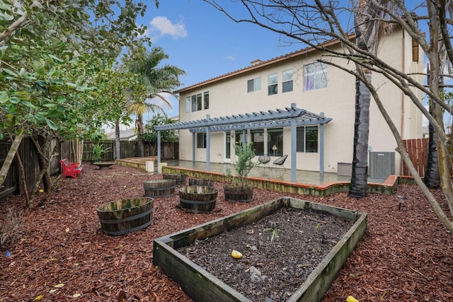 rear view of house with a patio, a fenced backyard, a garden, a pergola, and stucco siding