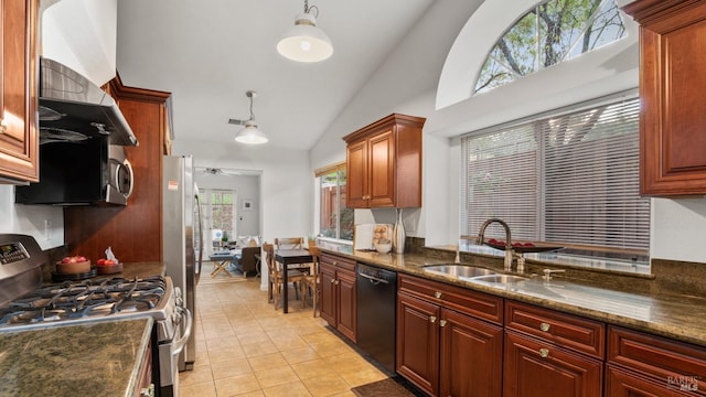 kitchen featuring light tile patterned flooring, stainless steel appliances, a sink, hanging light fixtures, and dark stone counters