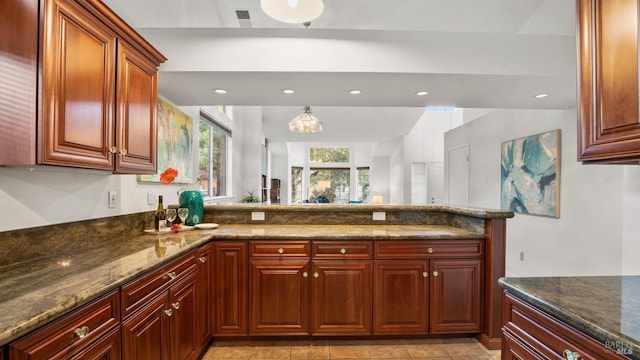 kitchen featuring dark stone counters, a peninsula, visible vents, and recessed lighting