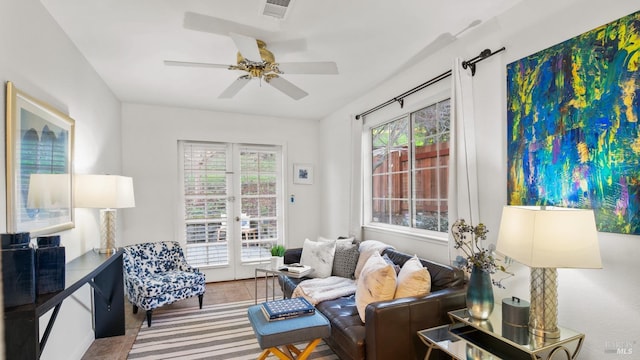 living area with french doors, visible vents, and a ceiling fan