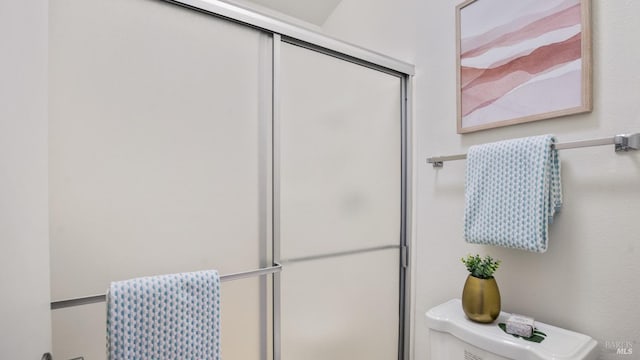 full bathroom featuring toilet and an enclosed shower