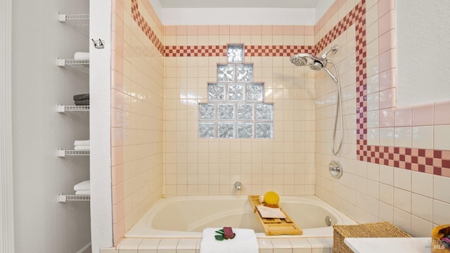 bathroom featuring tiled shower / bath and tile walls