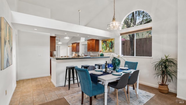 dining space featuring a chandelier, high vaulted ceiling, light tile patterned floors, recessed lighting, and baseboards