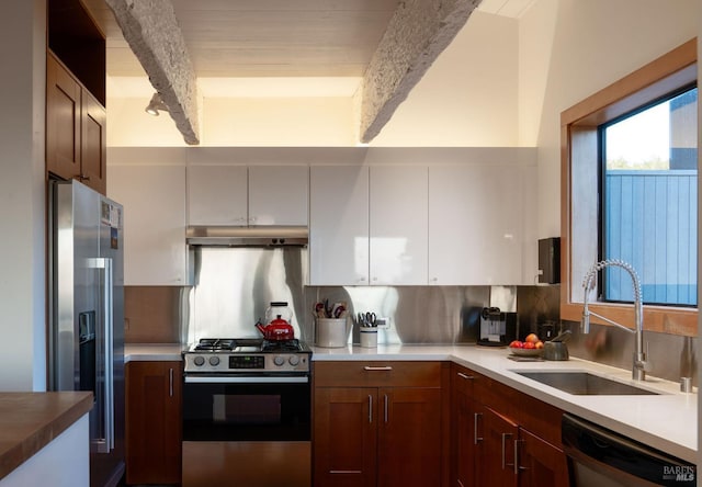 kitchen with backsplash, under cabinet range hood, beam ceiling, stainless steel appliances, and a sink