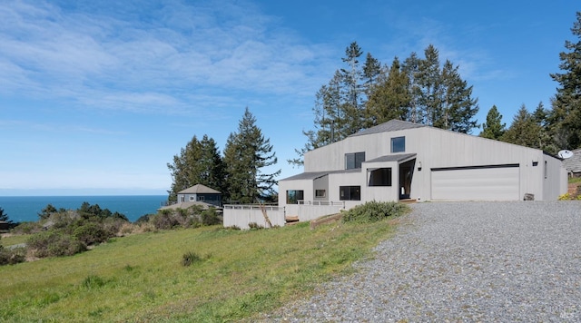 view of front of house featuring a garage and a water view