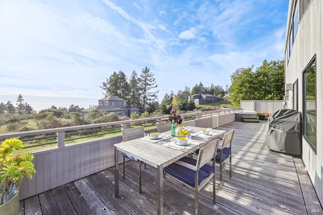 wooden deck with outdoor dining area and grilling area