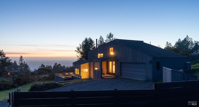 contemporary home with a garage and gravel driveway