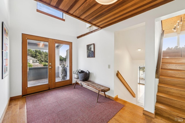 doorway featuring stairway, french doors, baseboards, and wood finished floors