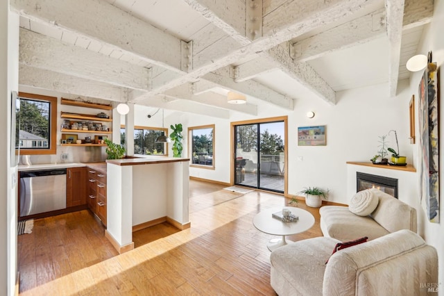 kitchen with a wealth of natural light, beam ceiling, and stainless steel dishwasher