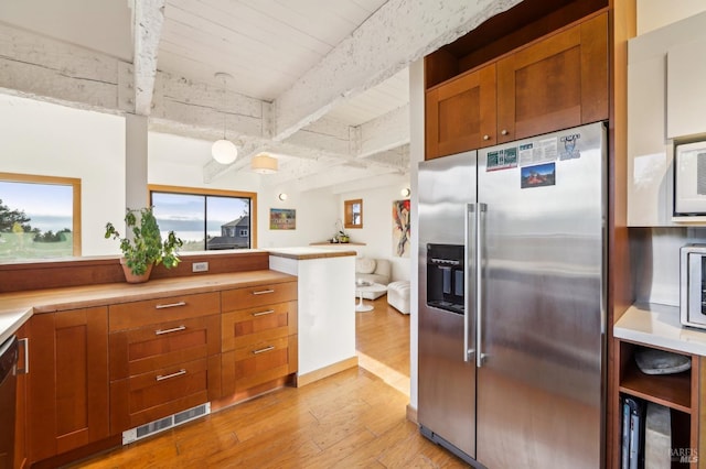 kitchen with visible vents, stainless steel appliances, light countertops, light wood-style floors, and beamed ceiling