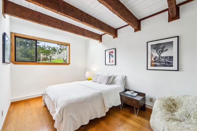 living area featuring hardwood / wood-style flooring, wood ceiling, and vaulted ceiling with beams