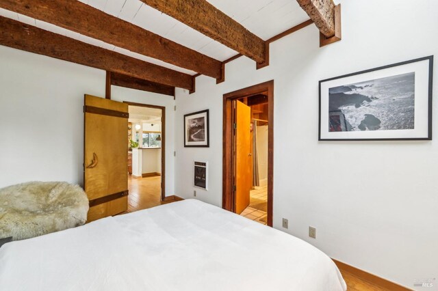 bedroom featuring wood ceiling, wood-type flooring, access to exterior, and lofted ceiling with beams