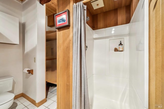 bathroom with wooden ceiling, toilet, and a stall shower