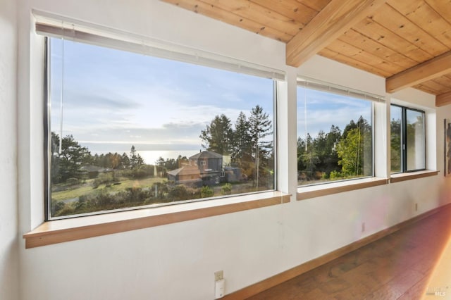 unfurnished sunroom featuring beamed ceiling and wooden ceiling