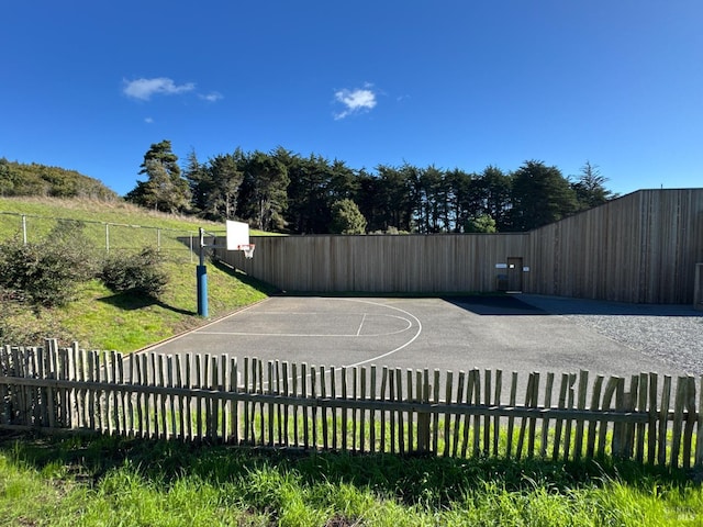 view of basketball court with fence and basketball court