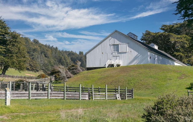 view of pole building with a yard and fence