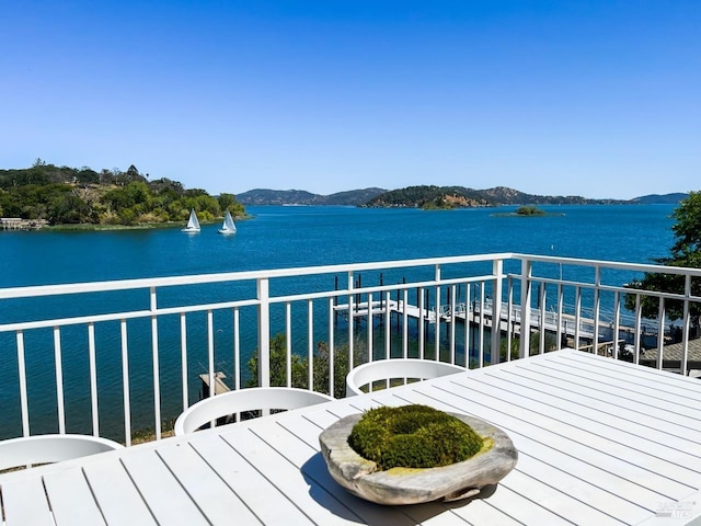 balcony featuring a water and mountain view