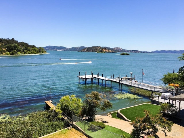 dock area featuring a water and mountain view and a lawn