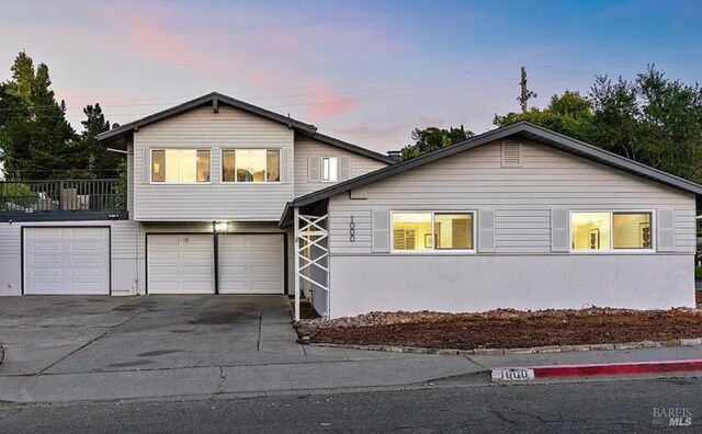 view of front of house with stucco siding, concrete driveway, and an attached garage