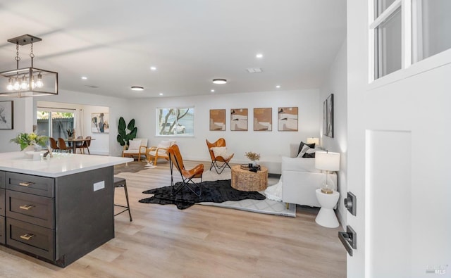 kitchen with a center island, light hardwood / wood-style flooring, a breakfast bar, and decorative light fixtures