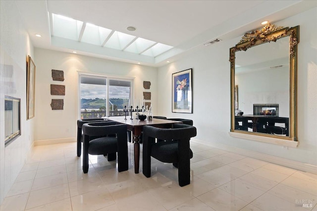 tiled dining room featuring a skylight