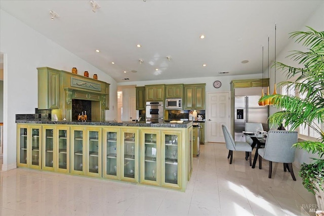 kitchen with green cabinets, built in appliances, lofted ceiling, and kitchen peninsula