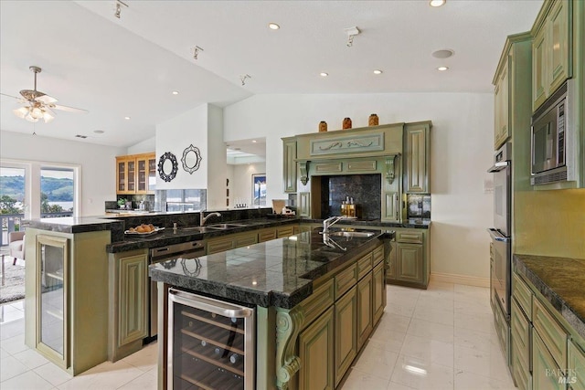 kitchen with a kitchen island with sink, wine cooler, kitchen peninsula, and green cabinets